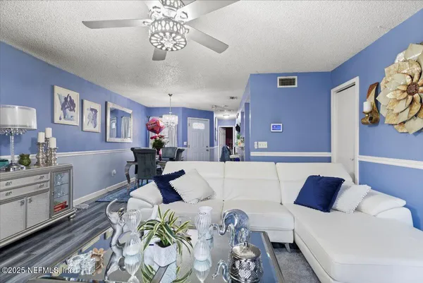 a living room with furniture and a chandelier