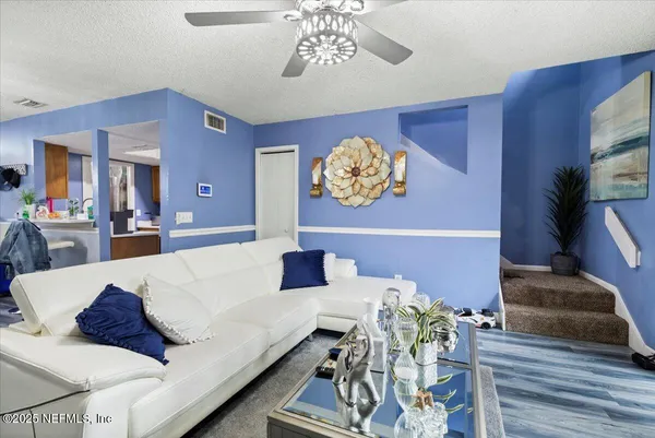 a living room with furniture and a chandelier