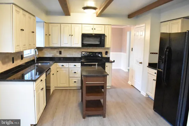 an empty room with wooden floor fireplace and windows