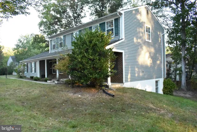 a view of a house with a yard and large tree