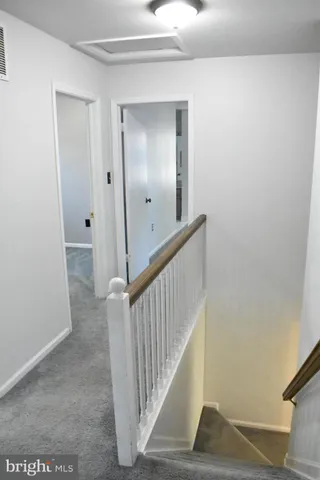 an empty room with windows and chandelier fan
