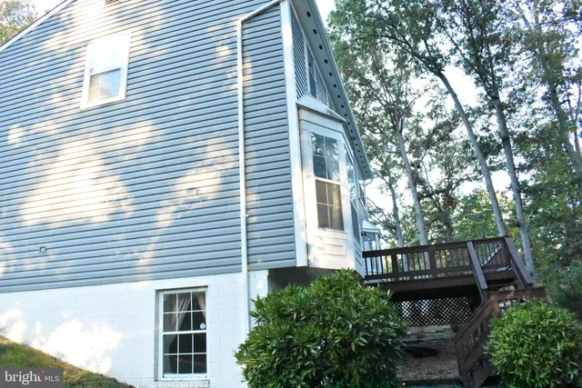 a view of a house with a window and wooden fence