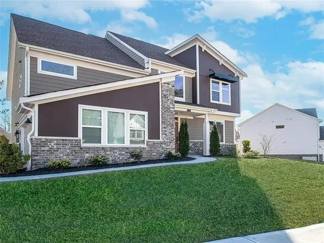 a front view of a house with a garden and yard