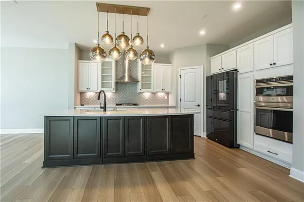 a kitchen with kitchen island granite countertop a sink cabinets and stainless steel appliances
