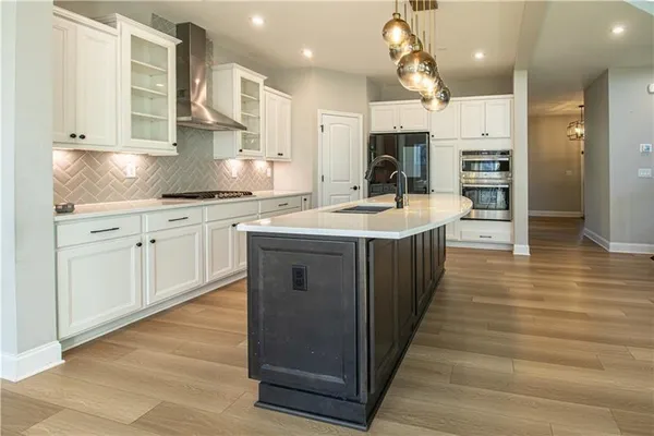a large kitchen with stainless steel appliances granite countertop a sink counter space and cabinets