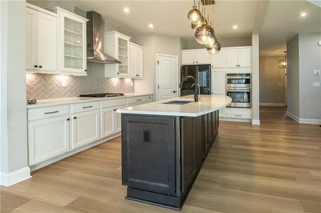 a large kitchen with stainless steel appliances granite countertop a sink counter space and cabinets