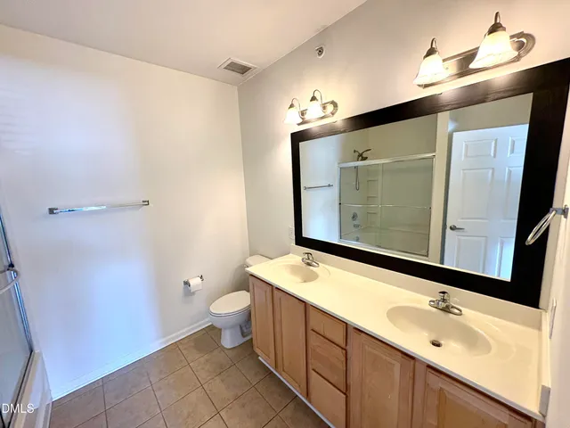 a bathroom with a sink a toilet and mirror