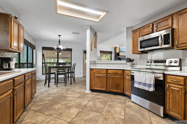 a kitchen with stainless steel appliances granite countertop a stove a sink and a microwave