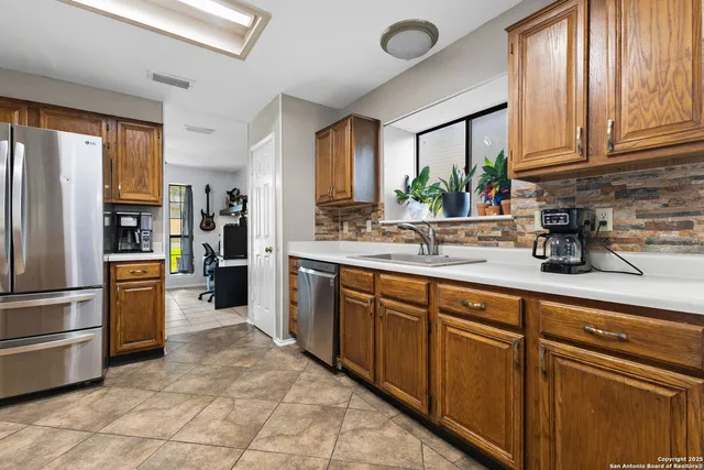 a kitchen with stainless steel appliances granite countertop a refrigerator sink and cabinets