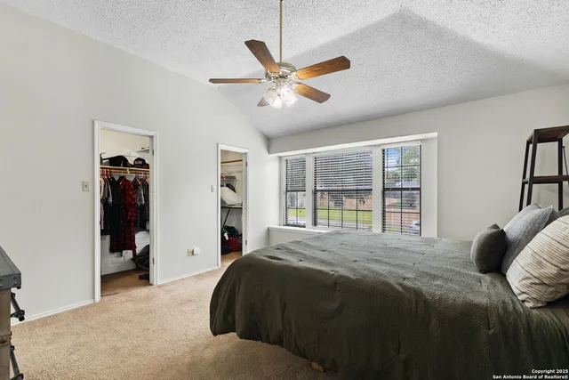 a bedroom with a bed and a large window