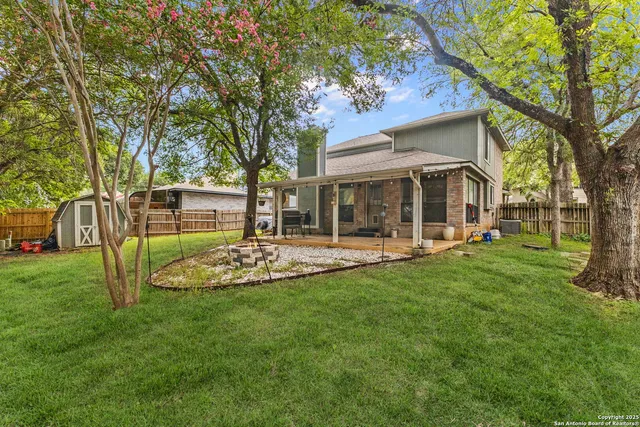 a view of a house with backyard and a tree