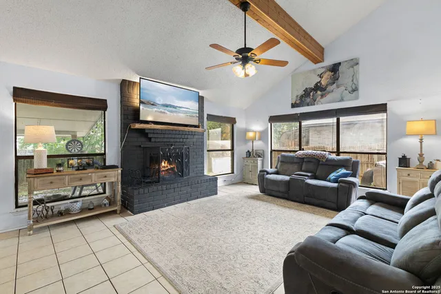 a living room with furniture a flat screen tv and a fireplace