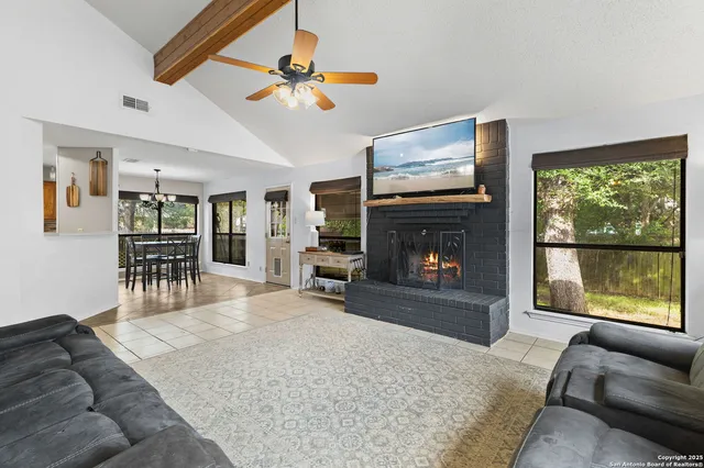 a living room with furniture a fireplace and a flat screen tv