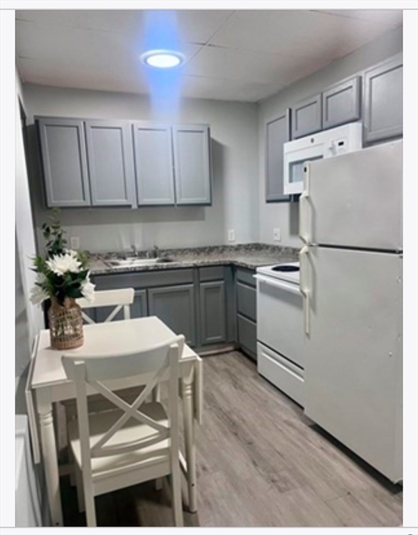 56 Johnson Street, Unit 16 Lynn, MA 01902 - Photo 2 of 5 a kitchen with a sink a stove a refrigerator and white cabinets