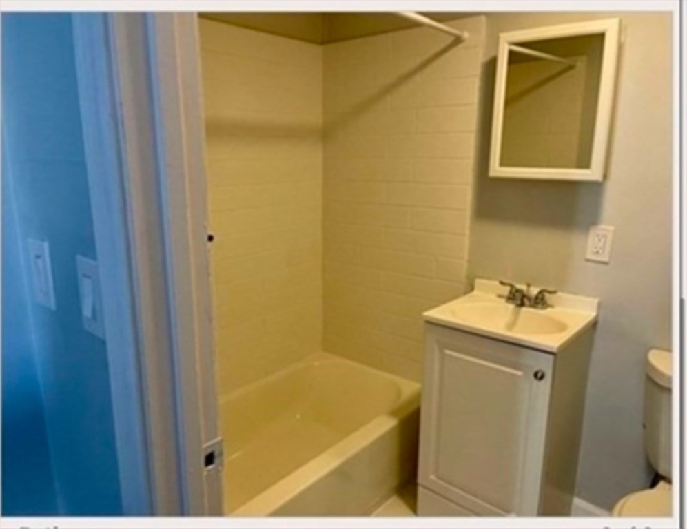 56 Johnson Street, Unit 16 Lynn, MA 01902 - Photo 5 of 5 a bathroom with a sink and mirror with shower