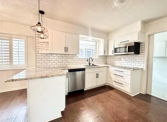 a kitchen with granite countertop white cabinets and white appliances