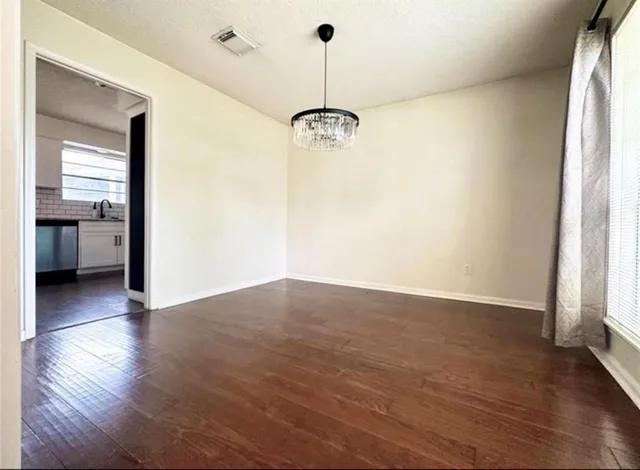 a view of a room with wooden floor and a window