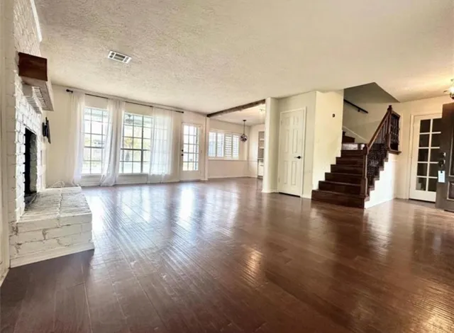a view of an entryway with wooden floors and stairs