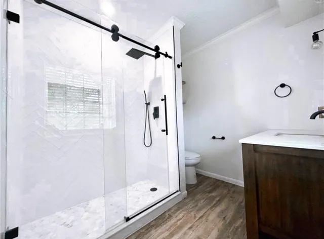 a bathroom with a granite countertop shower a toilet and a sink