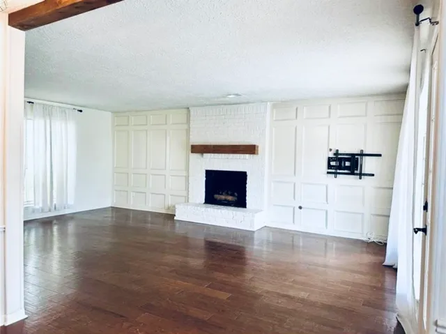 an empty room with wooden floor and fireplace