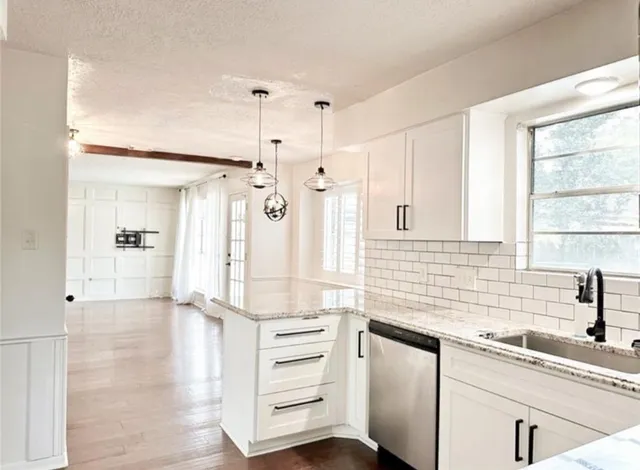 a kitchen with granite countertop white cabinets and white appliances