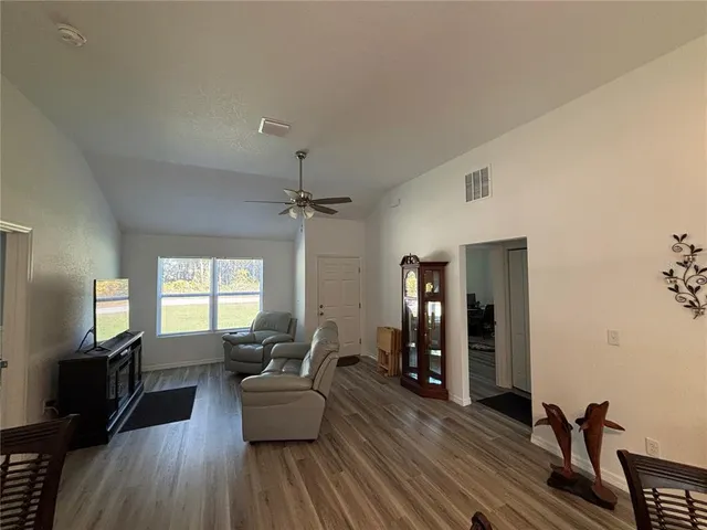 a living room with furniture and a wooden floor