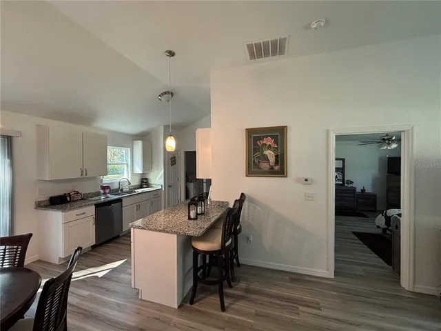 a kitchen with a table chairs refrigerator and cabinets