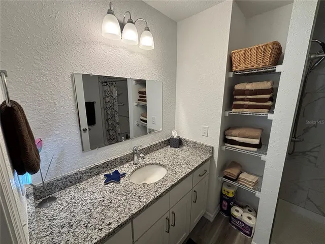 a bathroom with a granite countertop sink and a mirror