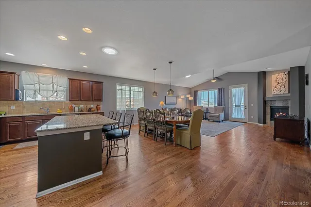 a kitchen with stainless steel appliances granite countertop wooden floors and view living room