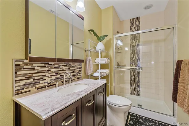 a bathroom with a granite countertop sink toilet and shower