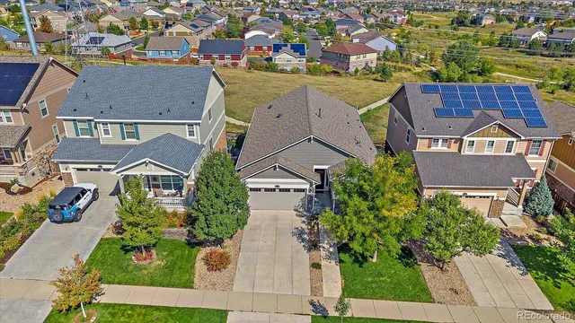 an aerial view of residential houses with outdoor space and parking