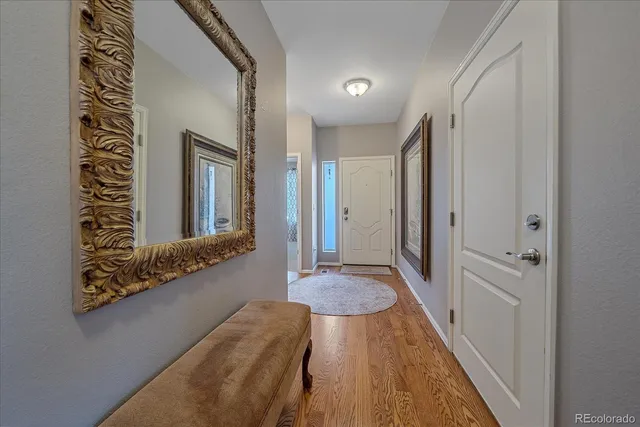 a view of a hallway with wooden floor and cabinet