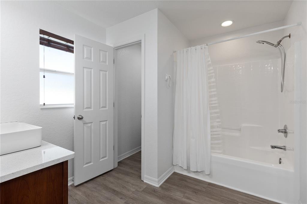 12374 Corrine Avenue Spring Hill, FL 34609 - Photo 12 of 28 a bathroom with a bathtub a shower a sink and a window