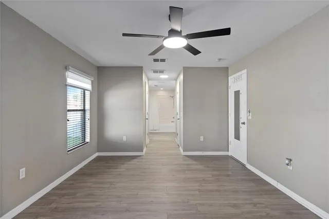 a view of an empty room with wooden floor