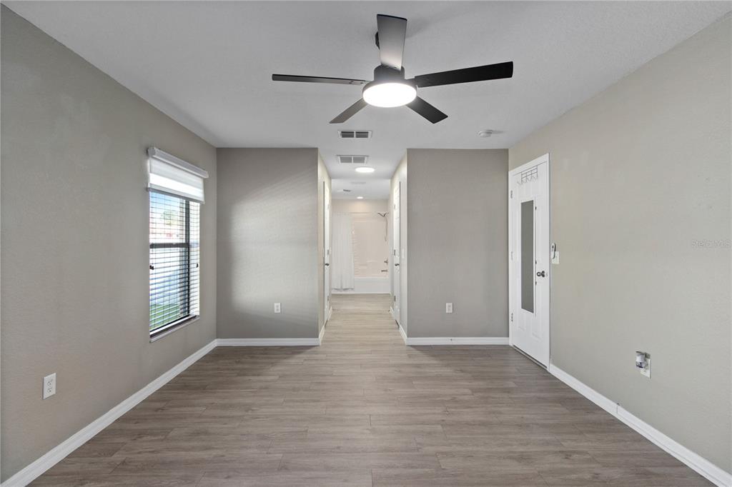 12374 Corrine Avenue Spring Hill, FL 34609 - Photo 16 of 28 a view of an empty room with window and wooden floor