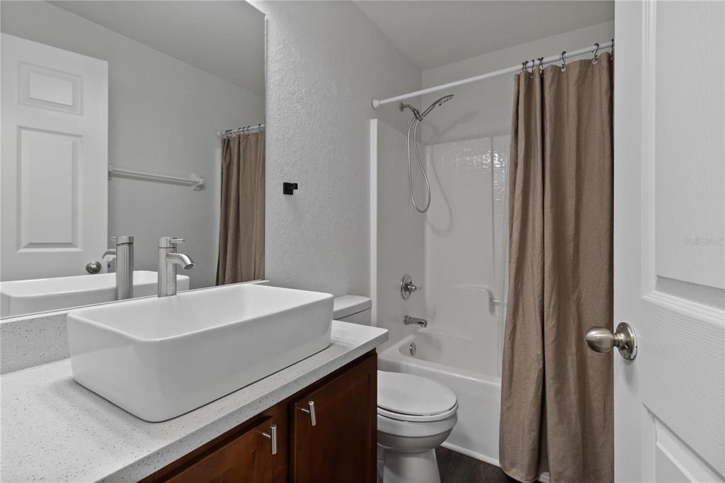 12374 Corrine Avenue Spring Hill, FL 34609 - Photo 17 of 28 a bathroom with a sink a toilet a mirror and shower