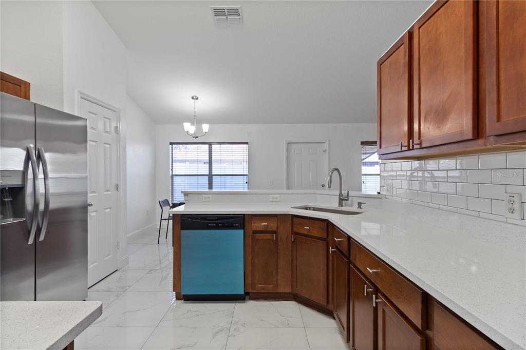 12374 Corrine Avenue Spring Hill, FL 34609 - Photo 25 of 28 a kitchen with a sink refrigerator and cabinets