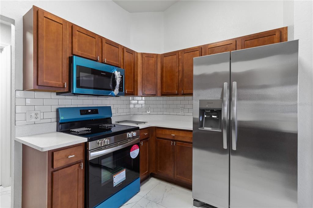 12374 Corrine Avenue Spring Hill, FL 34609 - Photo 27 of 28 a kitchen with a refrigerator stove and microwave
