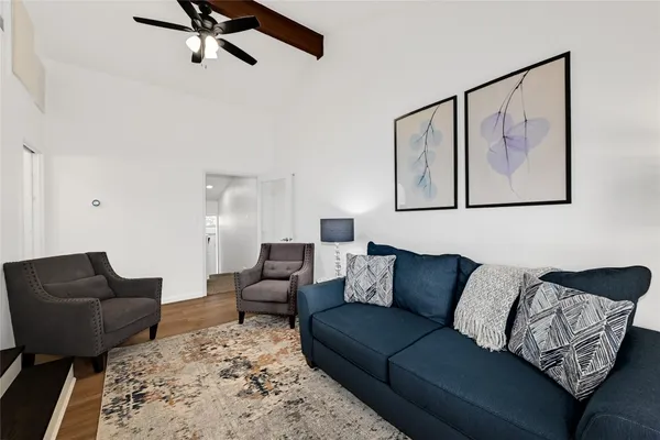 a living room with furniture and a wooden floor
