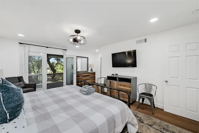 a bedroom with a bed and a flat screen tv on dresser