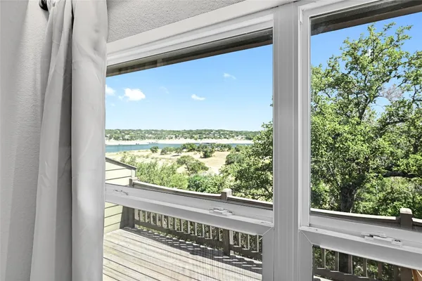 a view of a glass door with a balcony from a window