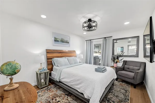 a bedroom with a bed and dresser with mirror