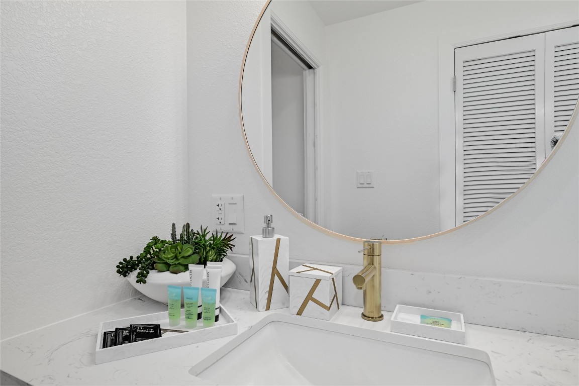 225 Comanche Lane Point Venture, TX 78645 - Photo 28 of 40 a bathroom with a sink a mirror and a potted plant