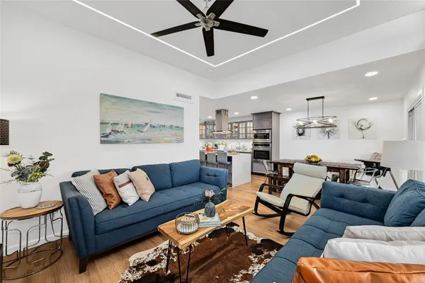 a living room with furniture kitchen view and a chandelier