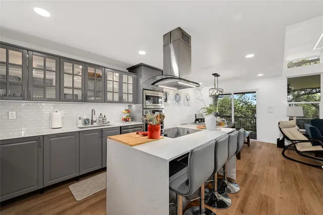 a kitchen with a sink a stove and chairs
