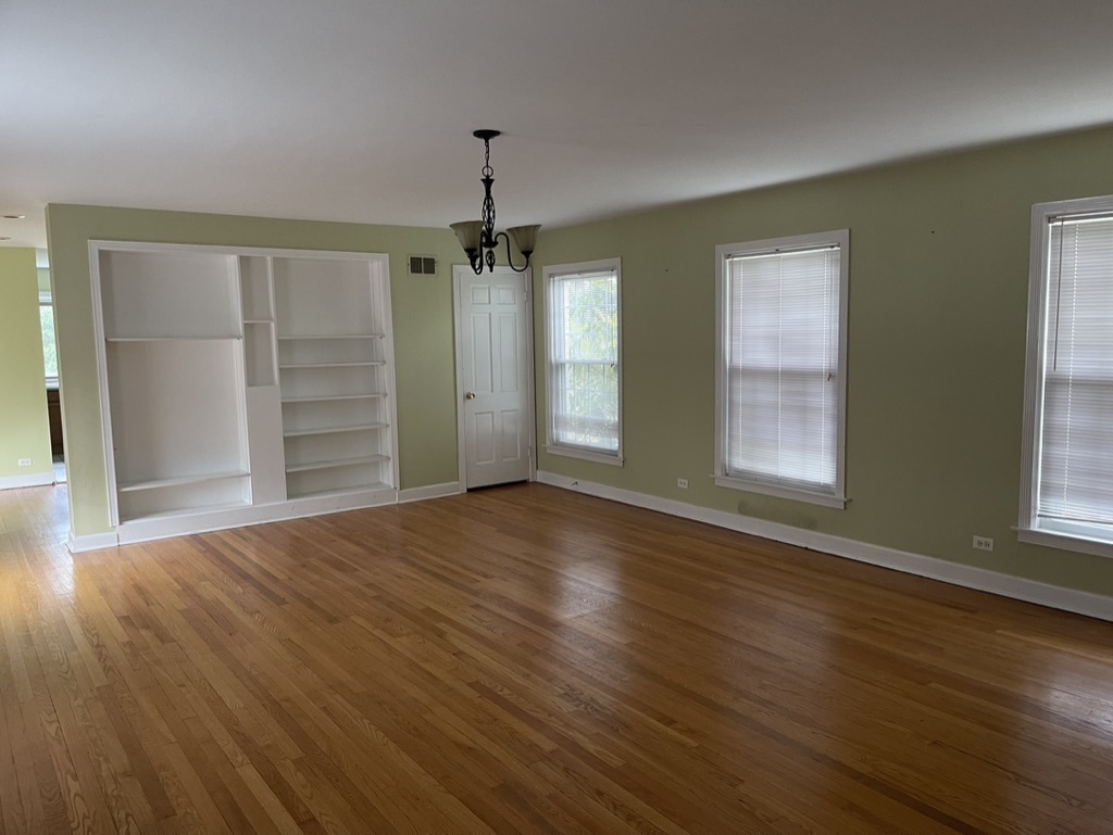 791 Braeburn Road Inverness, IL 60067 - Photo 3 of 14 an empty room with wooden floor chandelier and windows