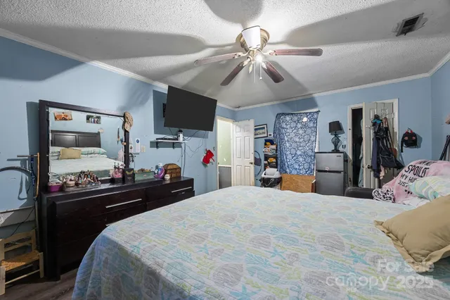 a bedroom with a bed and a large mirror on the dresser