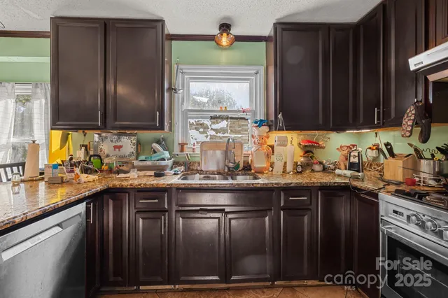 a kitchen with granite countertop a sink stove and cabinets