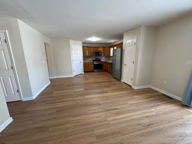 a view of a room with wooden floor and furniture