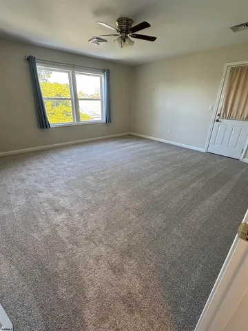 an empty room with windows and fireplace